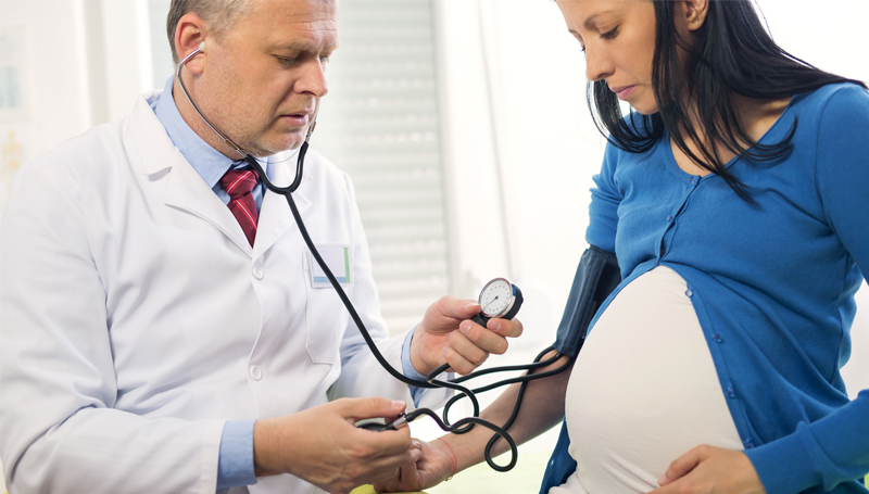 doctor checking pregnant woman's vital signs