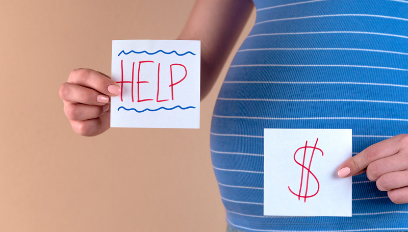 woman holding help and dollar sign notes by her pregnant belly