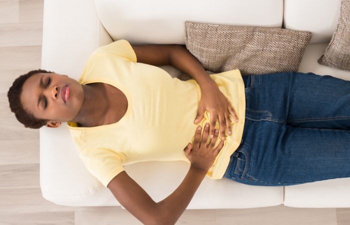 woman on couch feeling ill from morning sickness