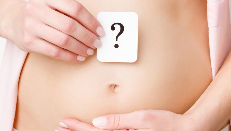 woman holding question mark over belly
