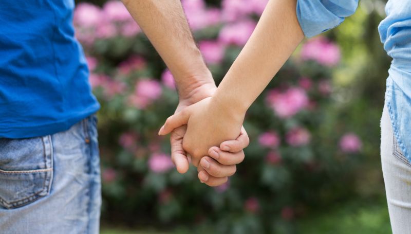 closeup of young couple holding hands