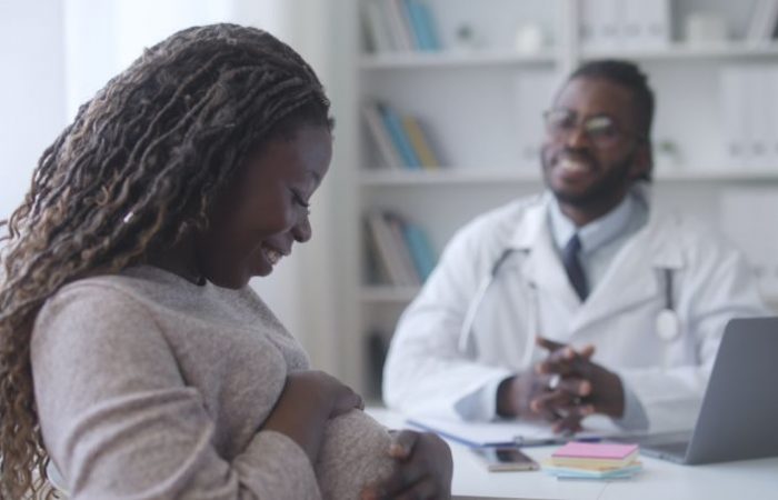 pregnant woman talking with doctor