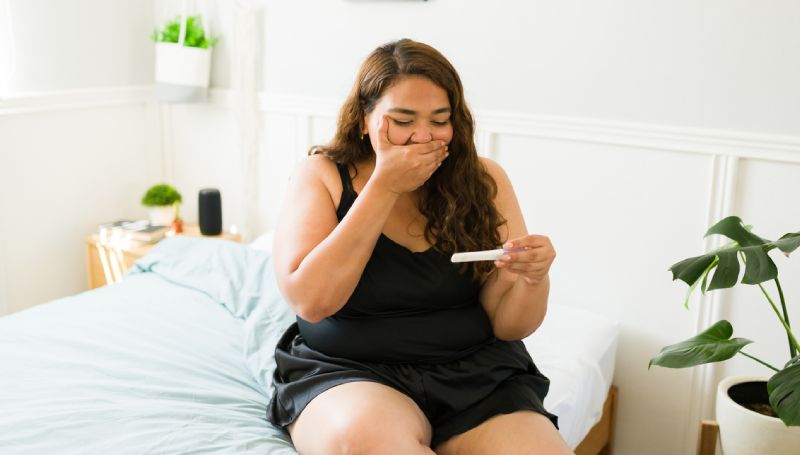 young woman seeing pregnancy test results